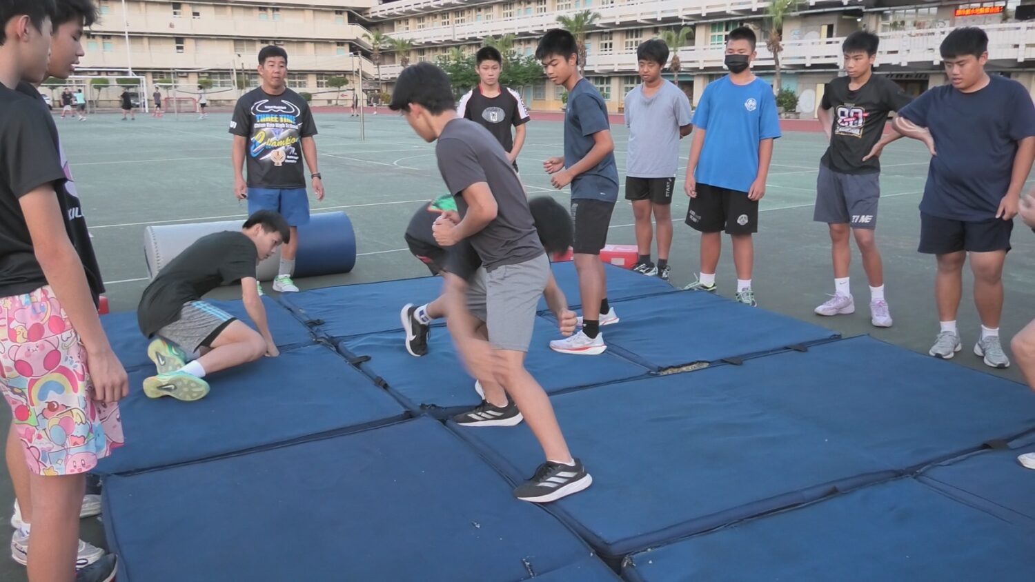 明志國中於水泥地操場鋪設軟墊,供球員練習撲倒動作。(圖/天合國際娛樂提供)