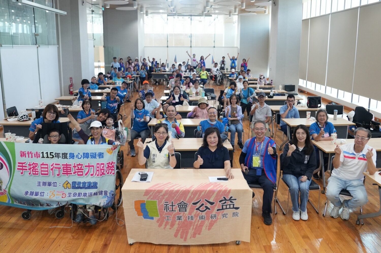 工研院攜手生命勵樂活輔健會舉辦「2026輪動未來 共融前行-無障礙自由車工研殿堂圓夢行動」,115位身心障礙朋友、家屬、志工齊聚工研院光明新村成功湖畔大會師合影,共同見證科技公益與多元共融的溫暖力量。(圖/工研院提供)