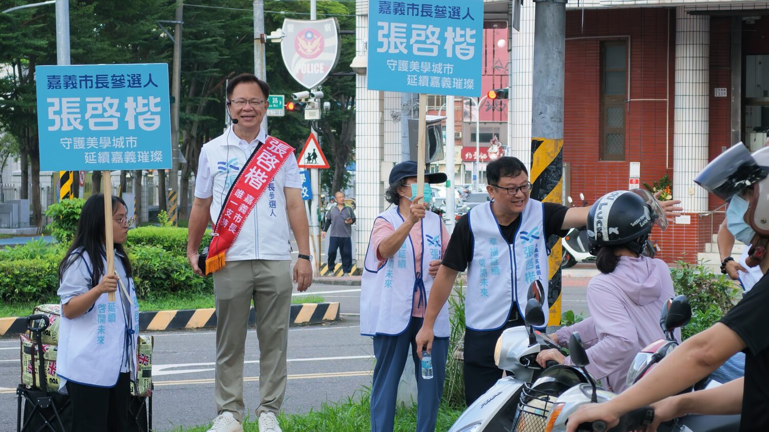 張啓楷一早站上街頭路口向通勤市民問候,爭取認同。(圖/記者翻攝)