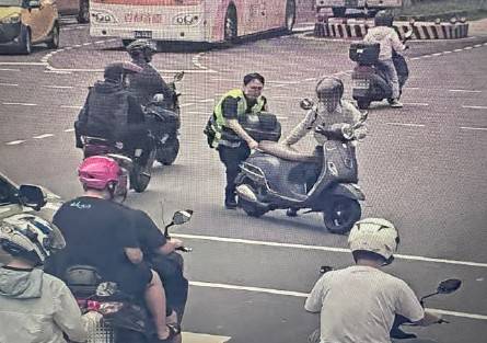 在場員警協助民眾推拋錨機車至路旁安全處。（圖／記者 戴昱弘翻攝）