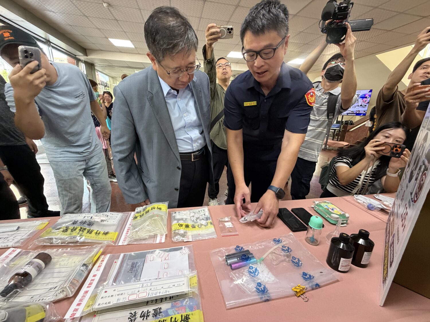 新竹縣政府警察局向媒體展示此次專案查扣的依托咪酯煙油、煙彈、製造器具、香精及包裝材料等證物,說明新興毒品犯罪手法及查緝成果。(圖/記者林照東攝)