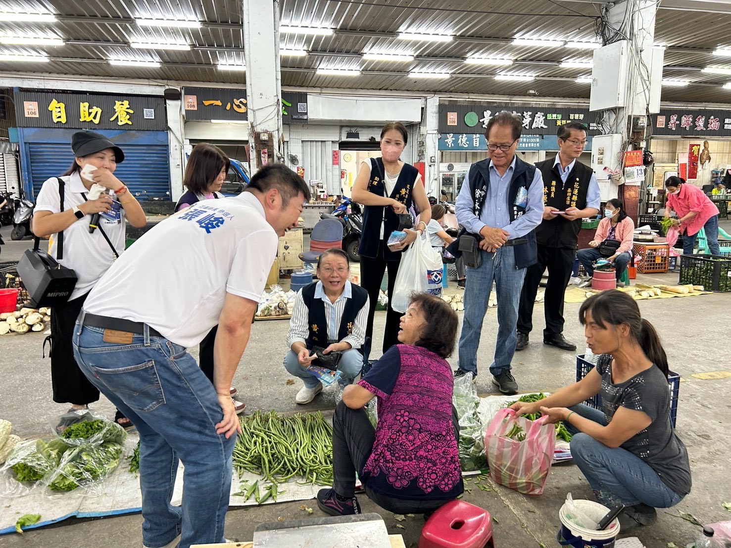 張峻(前排左一)在縣議員黃馨、林源富,吉安鄉民代表蘇文將及鄉民代表參選人羅勤翔陪同下,前往花蓮市果菜批發市場逐一向攤商與採買民眾問候並懇請支持。(圖/記者 趙靜姸翻攝)