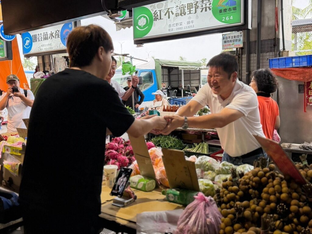 張峻（右二）今（23）日一早冒著細雨，前往花蓮市重慶市場拜訪攤商與鄉親，沿途逐一握手問候。（圖／記者 趙靜姸翻攝）