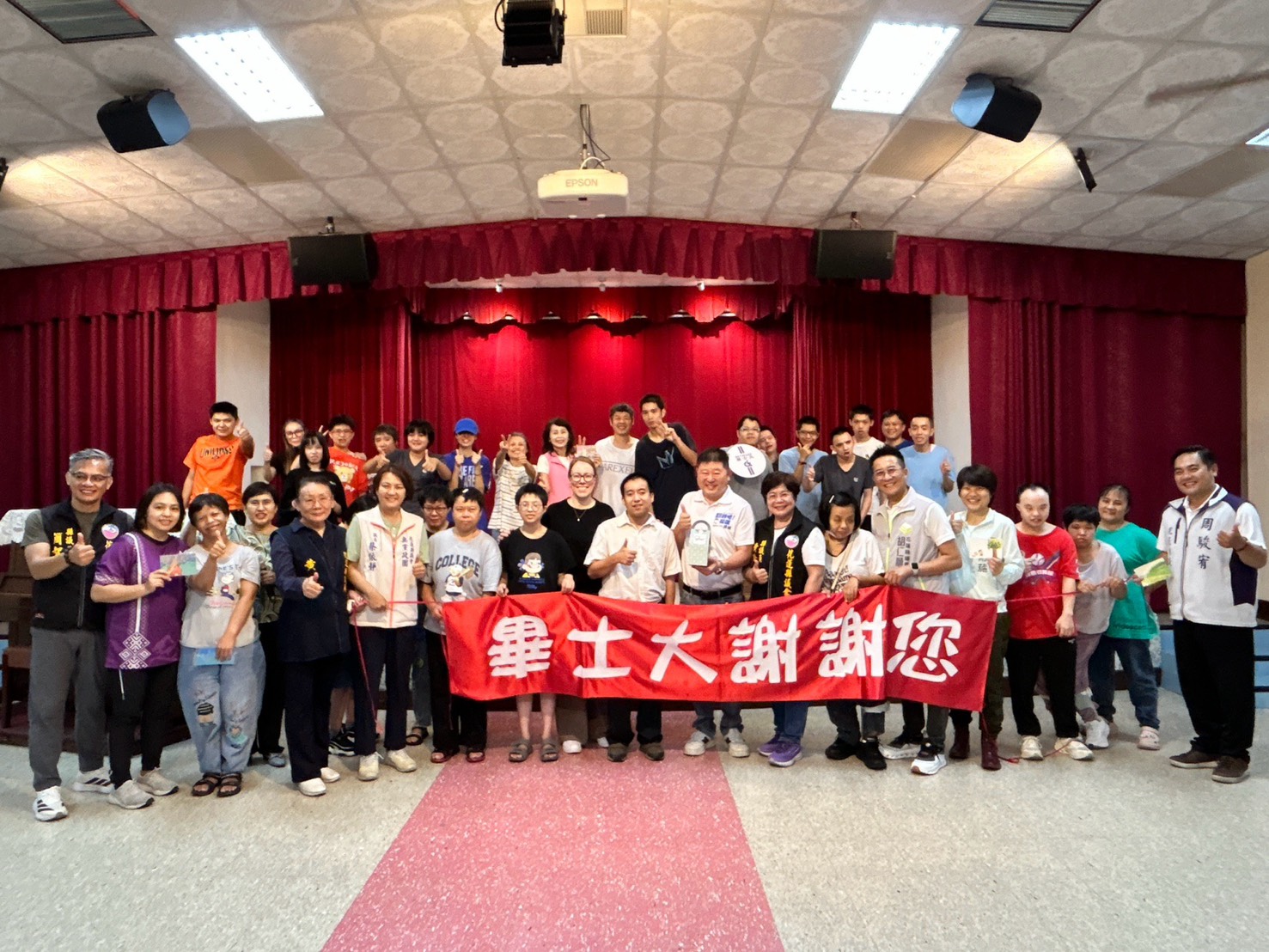 張峻(前排右九)和同行議員在畢士大教養院與院生共同合唱《在耶穌裡我們是一家人》。(圖/記者 趙靜姸翻攝)