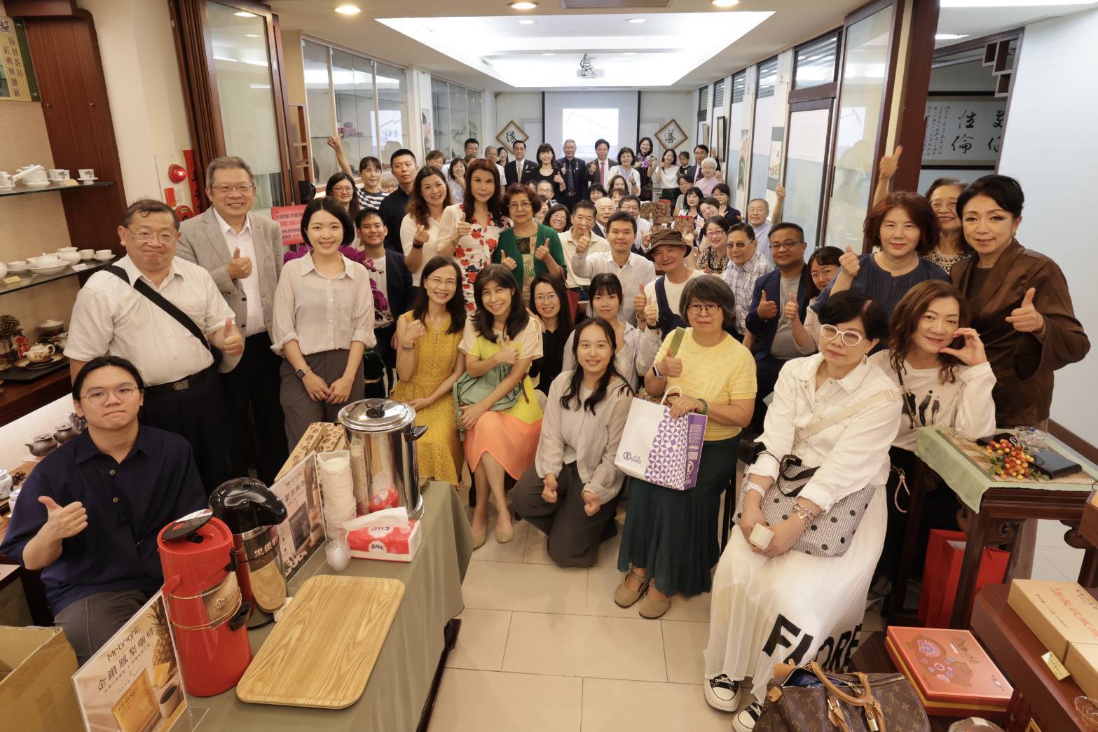 李兆環律師30周年感恩茶會大合照。會場上的書畫作品是李律師閒暇時完成的,掛在會場左右的「善」、「緣」兩字,讓感恩茶會顯得別具意義。(圖/記者翻攝)