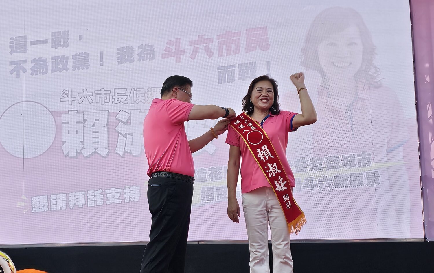 賴淑娞參選斗六市長競總成立,夫婿許舒博為妻披掛整理彩帶,場面溫馨。(圖/記者葉子綱攝)
