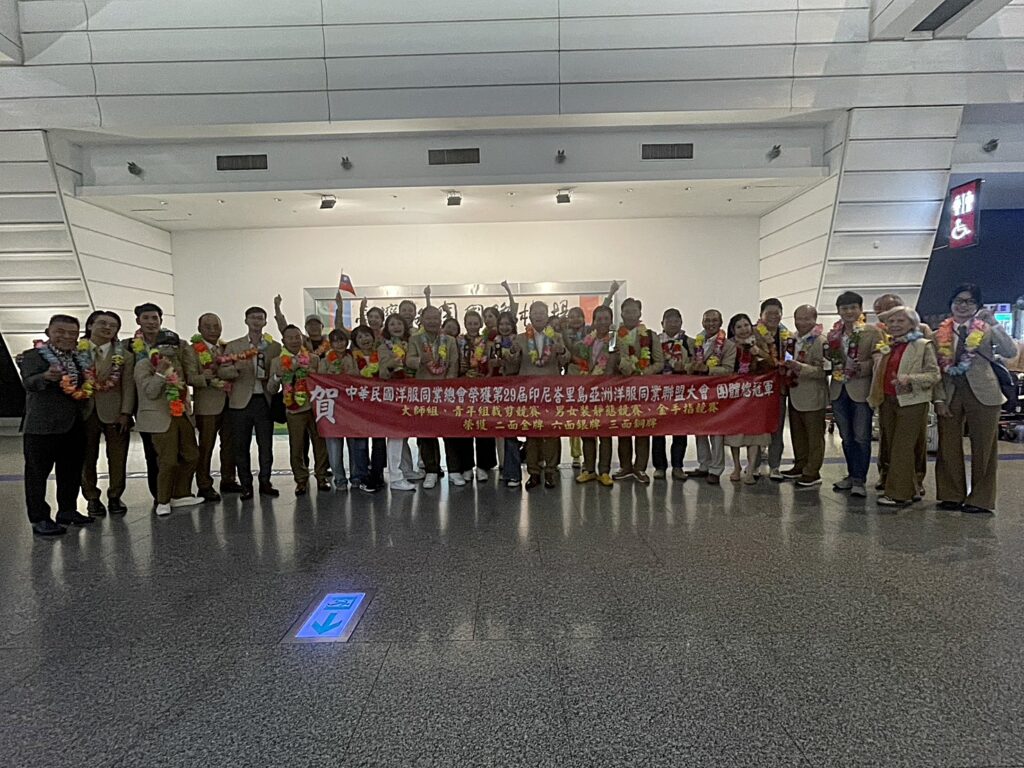 代表團凱旋歸國,於機場拉起紅布條慶祝榮獲團體總冠軍及多項大獎。(圖/臺北市西服商業同業公會提供)