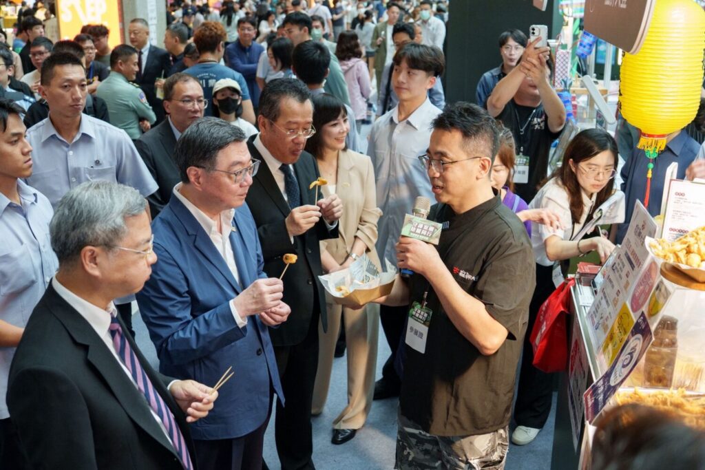 行政院卓榮泰院長走訪展售攤位，與業者親切互動，品嚐特色美食。(圖／經濟部商業發展署提供)