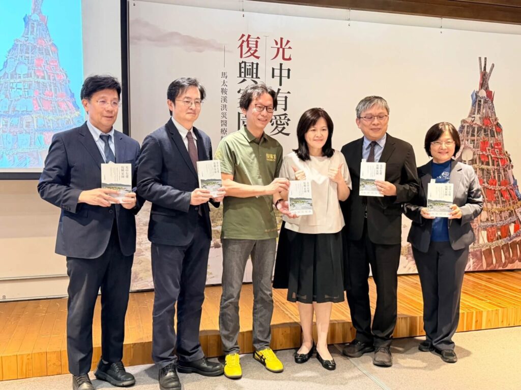 記者會貴賓們手持《光中有愛復興家園——馬太鞍溪洪災醫療紀實》合影，透過文字與影像保存馬太鞍溪洪災第一線醫療應變的珍貴經驗。（圖／記者張家燁翻攝）