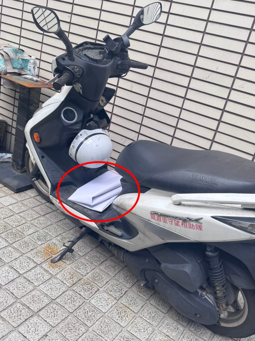 民眾拍下龍淵里現任里長汪吉秋撕毀海報後，放置機車踏墊上。（圖／林晏慈提供）