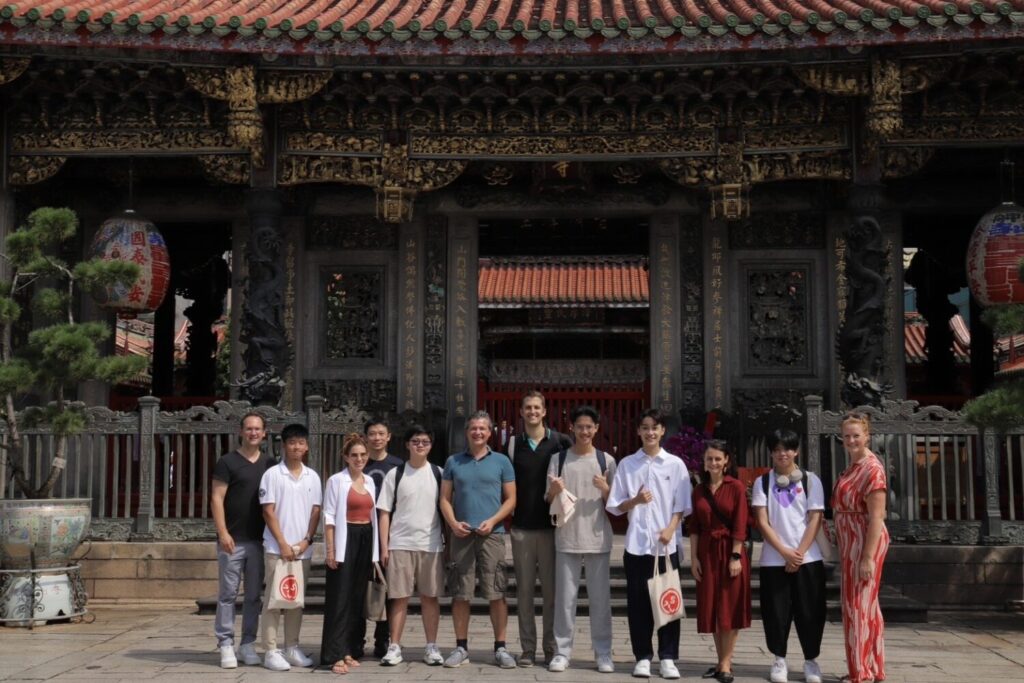 VIS推動Discover Taipei課程行之多年。學生從台北這座城市出發,把熟悉的生活場域轉化為學習的起點。圖為接待奧地利國會議員時,在龍山寺前的合照。(圖/(台北市VIS國際實驗高中提供)