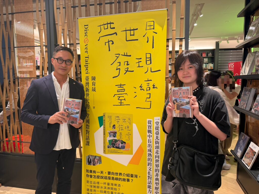 VIS 《帶世界發現臺灣》的設計扉頁插圖,出自該校十一年級學生梁栩溱(右)的手筆。他在新書發表會現場分享其創作理念,並與VIS執行長黃禮騏(左)合影。(圖/台北市VIS國際實驗高中提供)