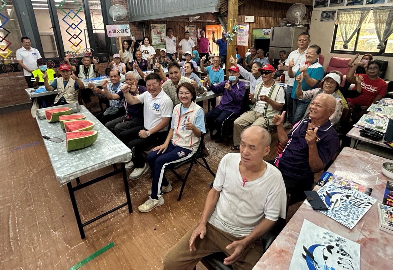 張峻(前排右二)還親手切西瓜與長輩分享,平均刀工獲讚「議長很專業」,現場氣氛溫馨熱絡。(圖/記者 趙靜姸翻攝)