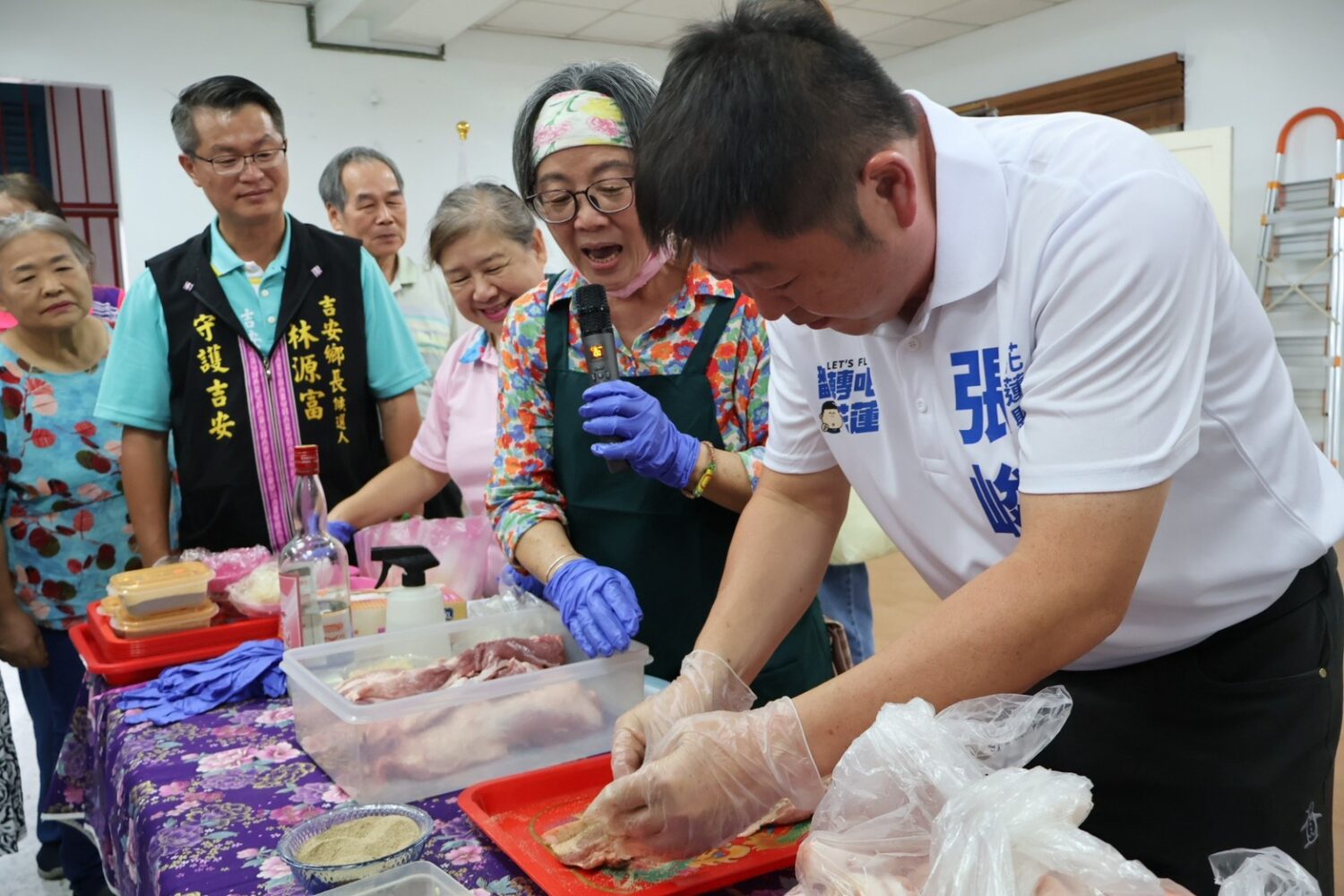 活動中,陳老師幽默表示,「今天我的助手就是張峻議長」,當場邀請張峻(右一)一同製作鹹豬肉。(圖/記者 趙靜姸翻攝)