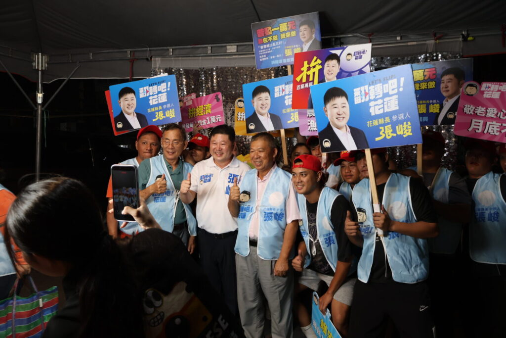 張峻(前排左三)一行走進和平村與長輩、小朋友合照,沿途烤肉香氣與笑聲交錯,也讓這趟中秋走訪多了幾分「回家過節」的親切感。(圖/記者 趙靜姸翻攝)
