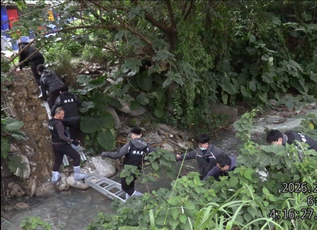 查緝人員架梯橫跨溪流及翻越小山丘。(圖/記者 趙靜姸翻攝)