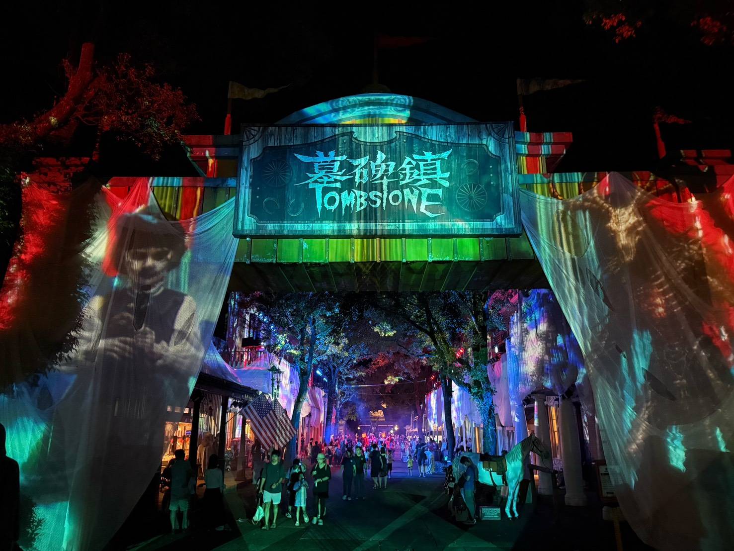 六福村「墓碑鎮」迎來10週年,夜間透過燈光投影與恐怖場景營造沉浸式萬聖氛圍,吸引遊客夜間探索,帶動樂園夜間經濟。(圖/記者張家燁翻攝)