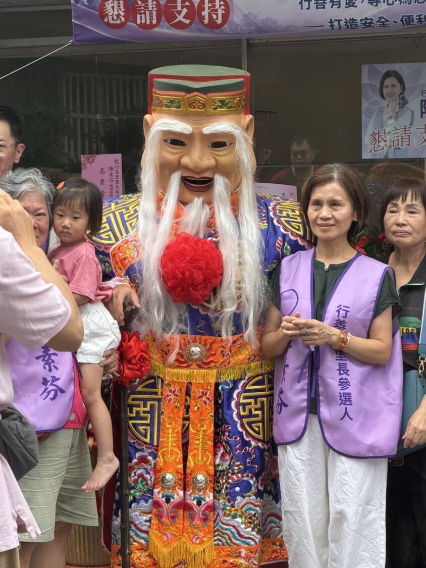 陳素芬宣示全力拚選戰,爭取成為下一任的行善里里長,土地公人偶也來站台。(記者包克明 攝)