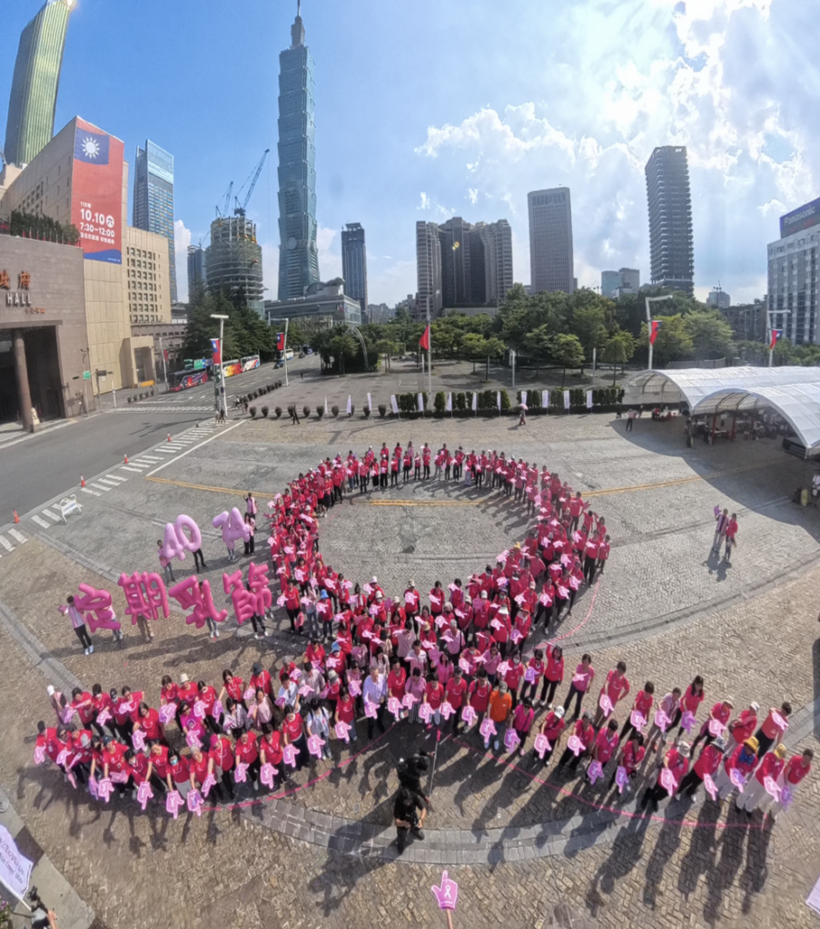 中華民國乳癌病友協會集結400位病友排出大型粉紅絲帶圖騰,呼應活動主題「40–74,是妳的事!定期乳篩,PINK健康!」。期盼女性朋友定期乳篩,守護健康。(圖/中華民國乳癌病友協會)